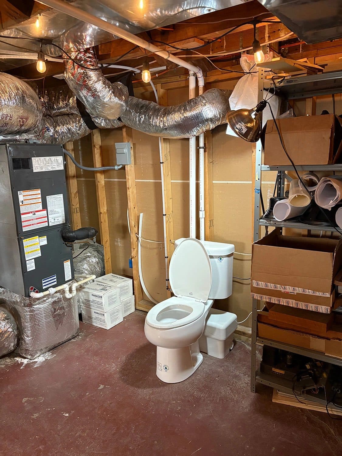 Toilet installed in a basement utility area during a bathroom addition
