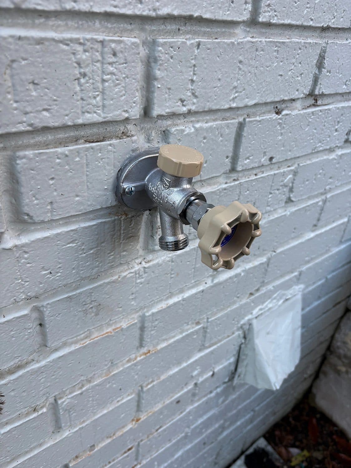 New frost-free hose bib installed on the brick exterior of a home