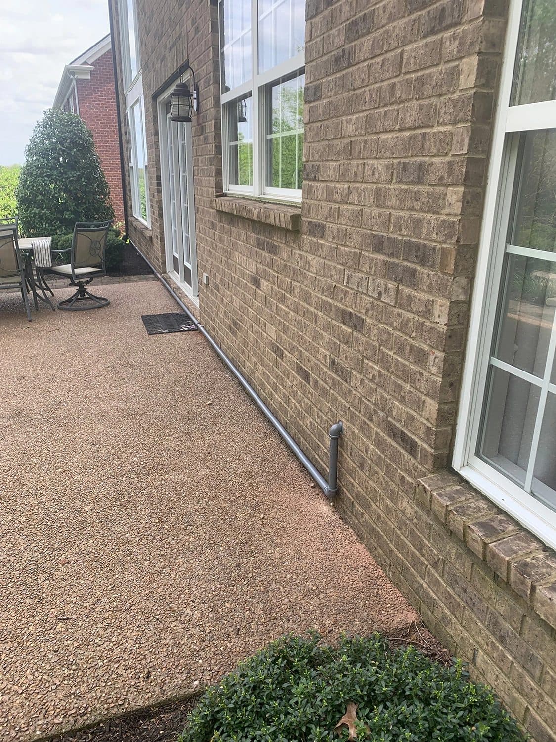 New residential gas line run along the side of a house next to the patio