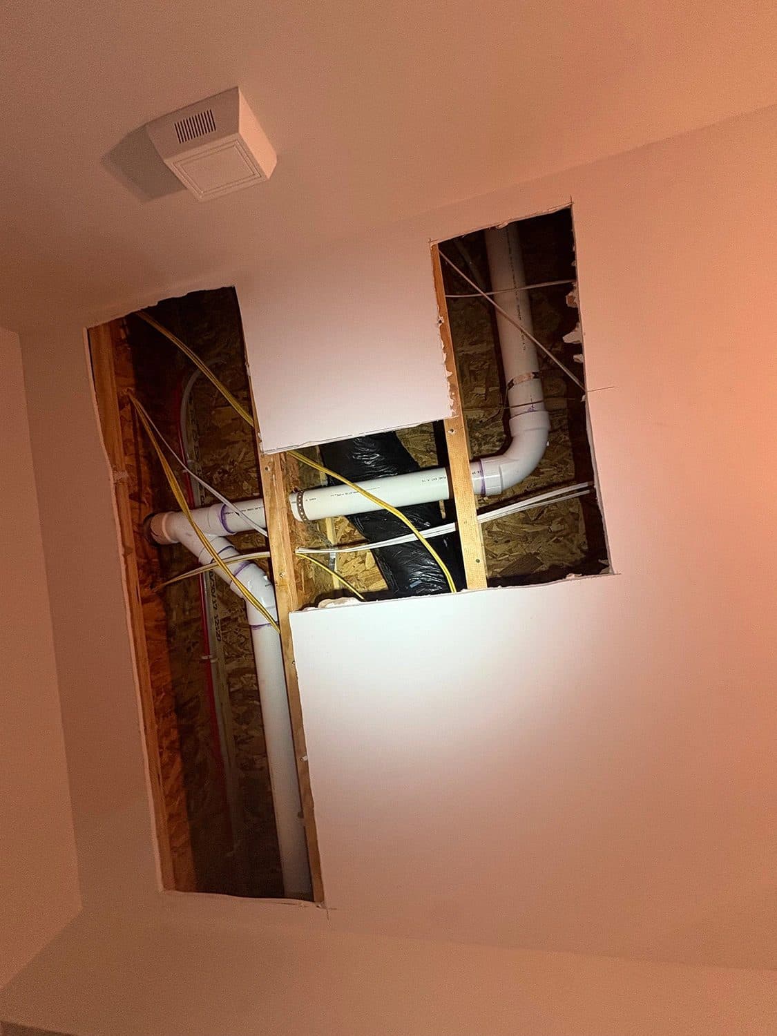 New water lines run through an opened ceiling during a whole-house repipe