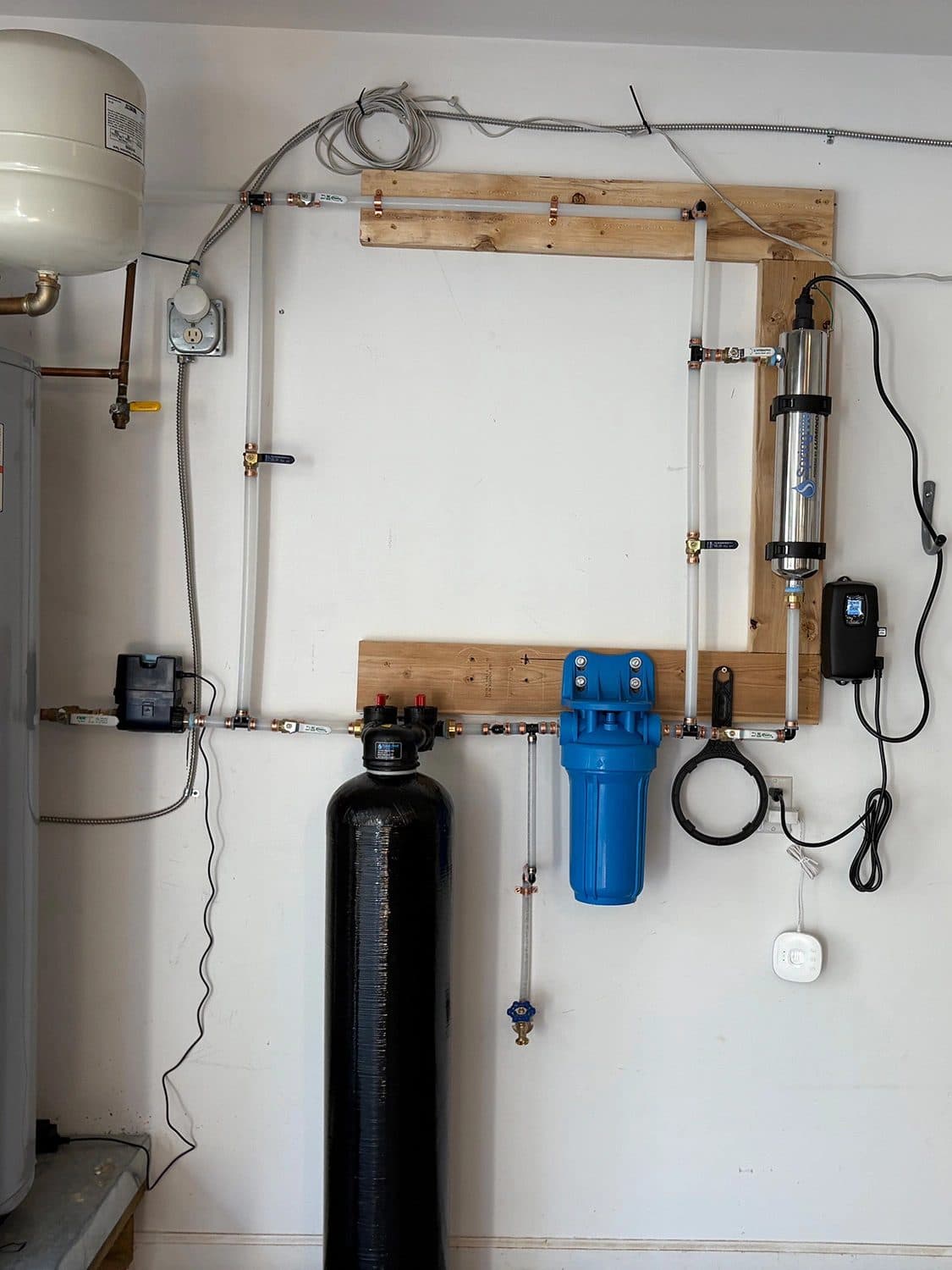 Water softener and whole-house filtration system installed on a garage wall
